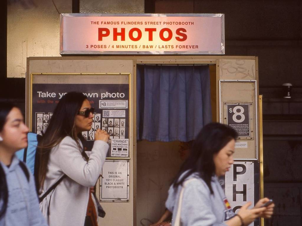 people walking past the Flinders St Photobooth