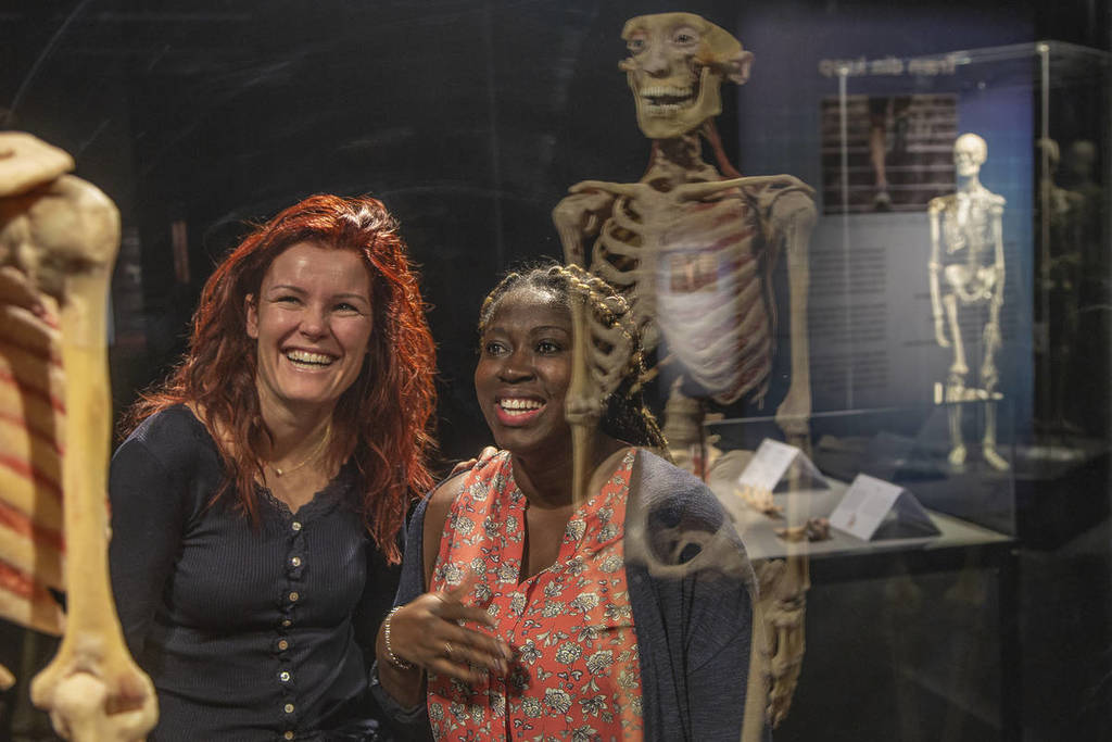Two women look at a skeleton model at BODY WORLDS.