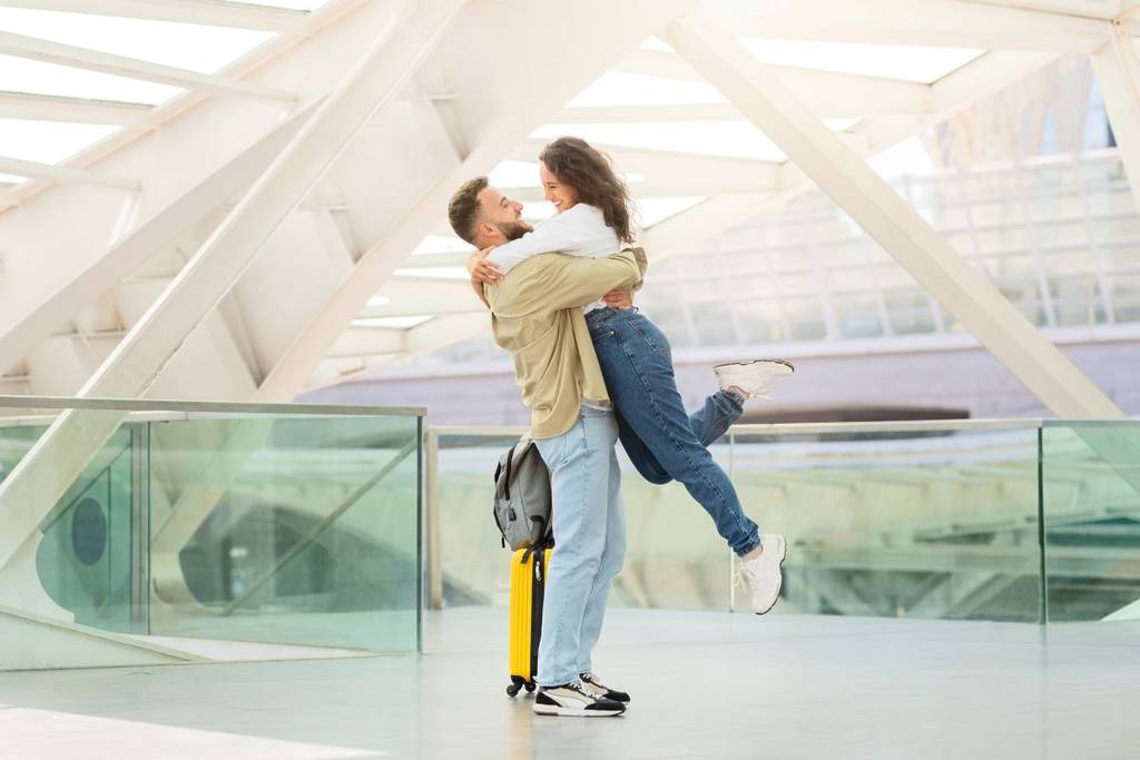 couple in romantic embrace at airport during valentines travel