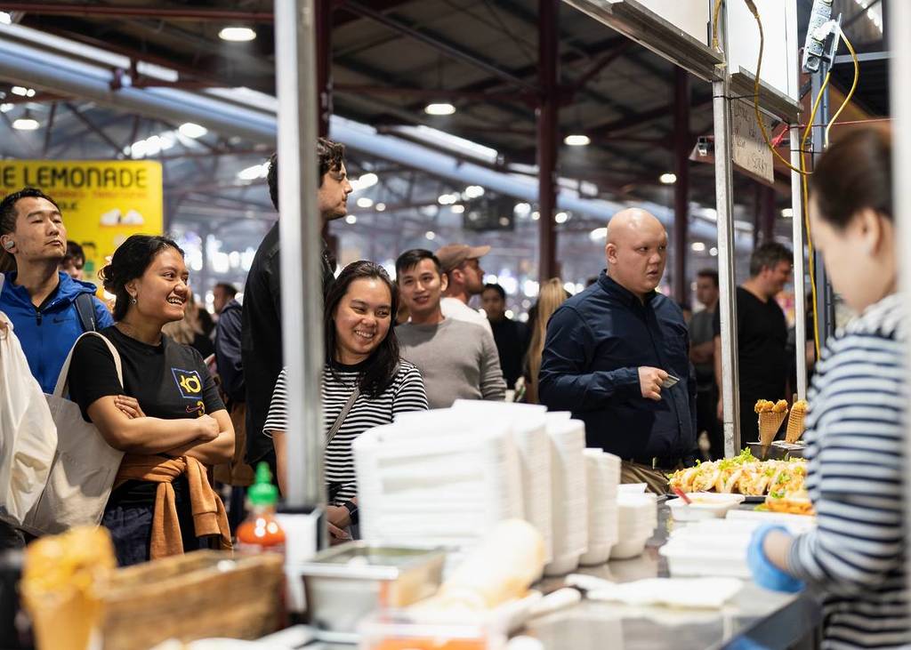 people waiting for food at one of the nightmarkets at Queen Victoria Market