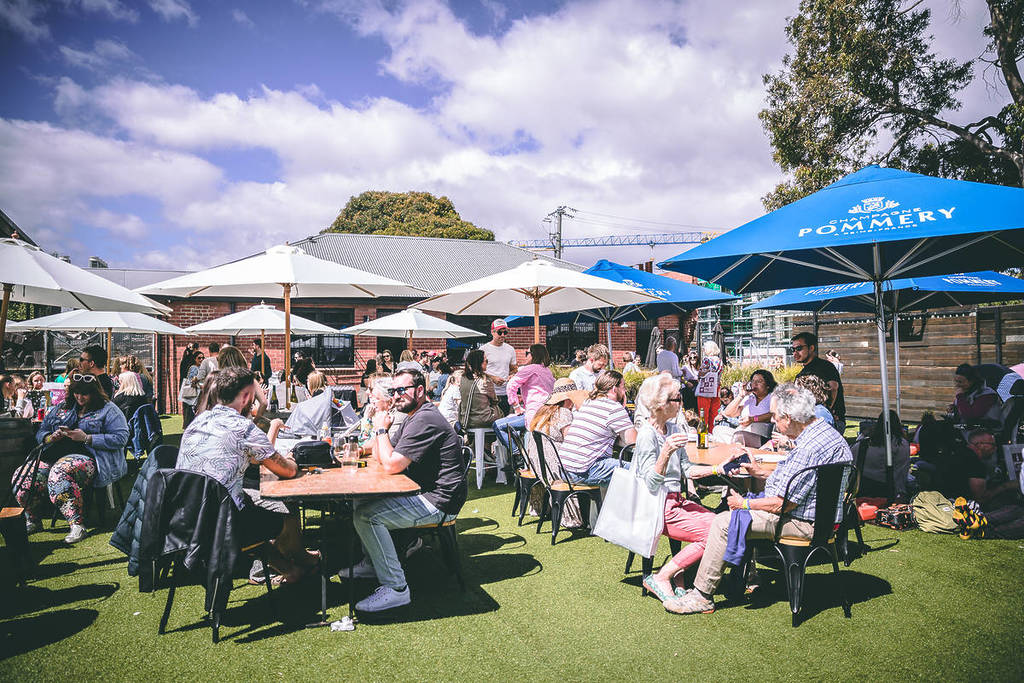 people sitting outdoors at picnic tables at Wine & Cheese Fest