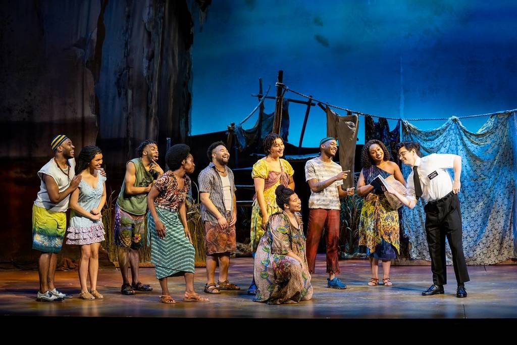 Ugandan characters listening to Elder Cunningham as he pretends to teach them about the Book of Mormon