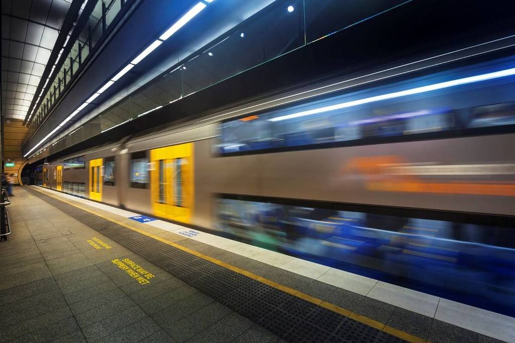 a double decker train in Sydney zooming past the platform