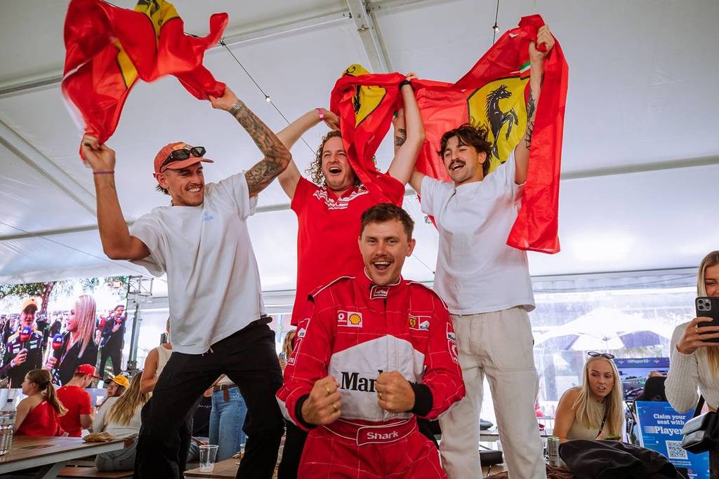fans cheering and waving Formula 1 flags at Middle Park Hotel street party