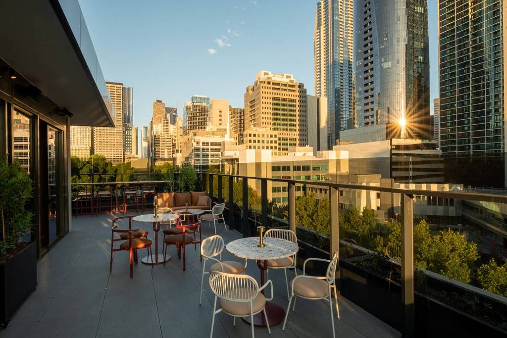 the terrace at Foundry on Mercure Melbourne La Trobe Street during golden hour, with sunny city skyline in the background