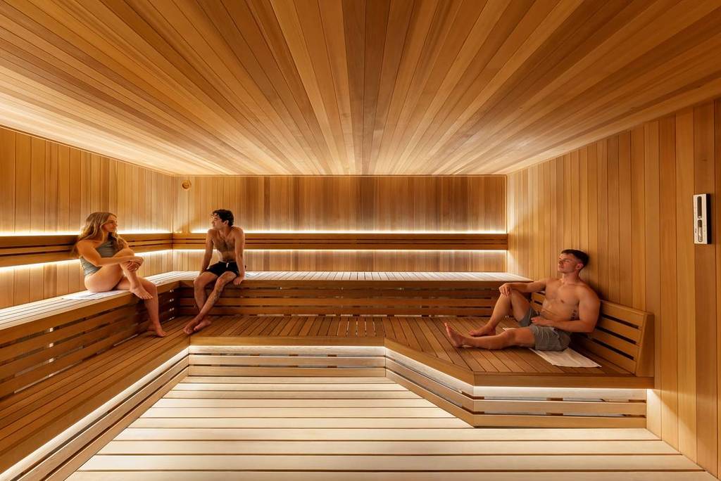 three people relaxing in a sauna at The Commons Health Club