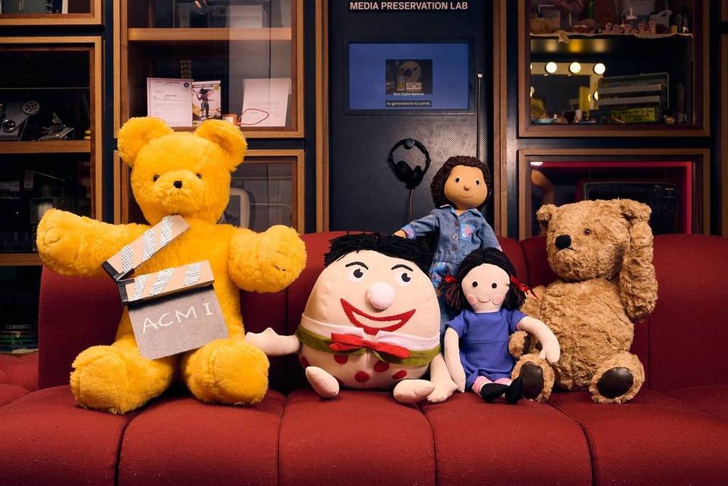characters from Play School like Big Ted, Humpty and Jemima on a couch at ACMI