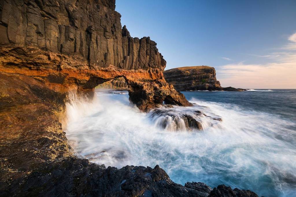 waves crashing against a natural rock arch at Bushrangers Bay