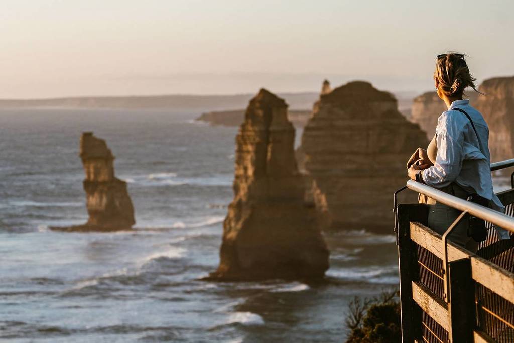 visitor looking at the twelve apostles at sunset