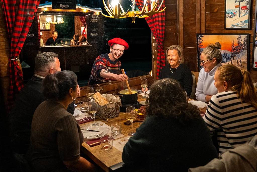 people inside a chalet enjoying fondue