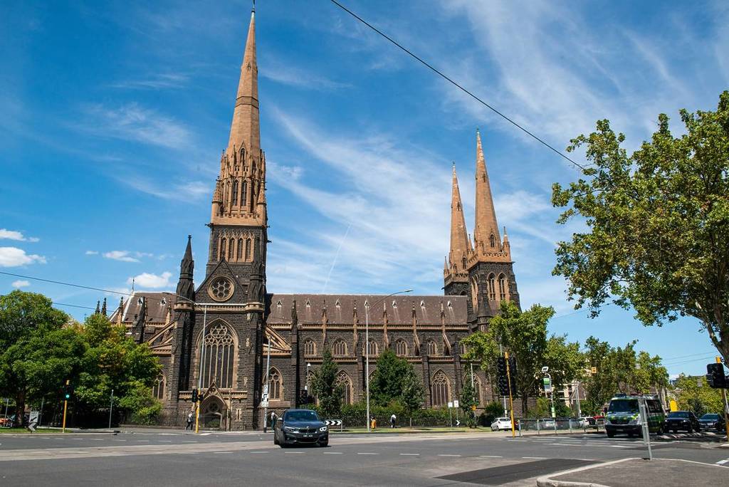 a view of St Patrick's Cathedral from the street, with a car parked in front