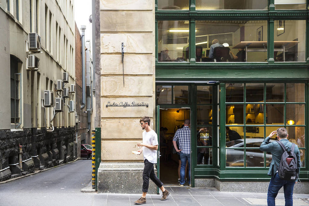 person walking past Dukes Coffee Roasters on Flinders Lane