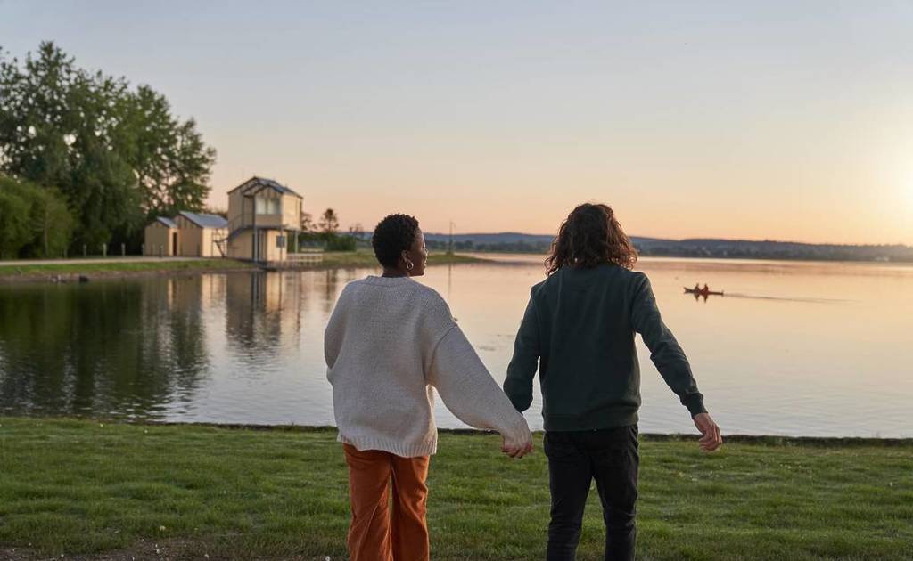 couple holding hands at sunset looking out at Lake Wendouree in Ballarat