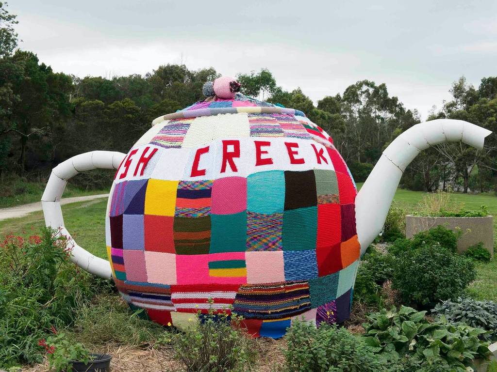 a sculpture of a tea pot in Fish Creek, covered in knitted patches
