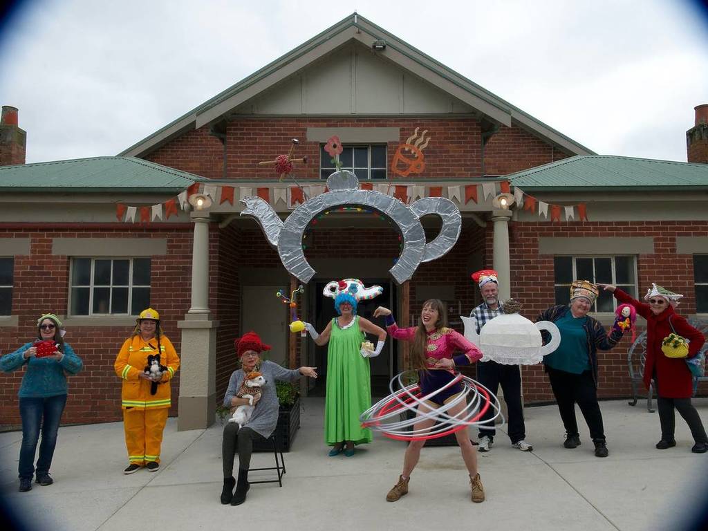 people dressed up and posing as tea pots in front of a community hall in Fish Creek
