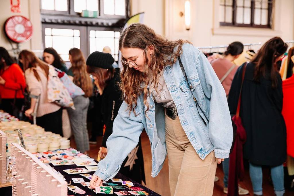 woman looking at accessories at Round She Goes market