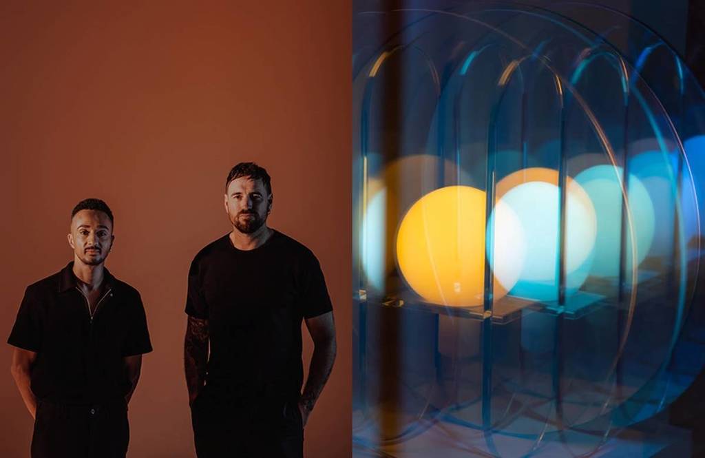 two male artists next to a light sculpture