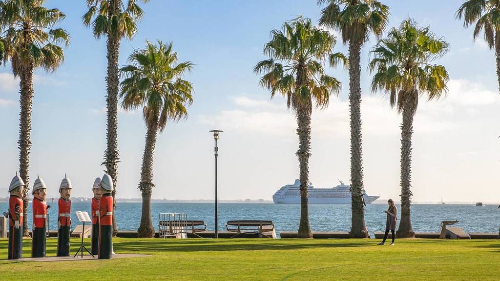 the lifeguard bollards in Geelong with palm trees and a cruise ship in the background