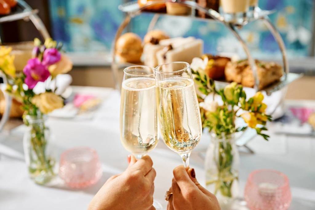 women clinking champagne glasses at a high tea in The Westin Melbourne