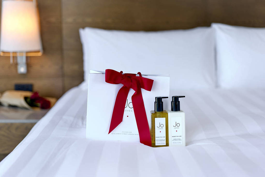 Jo Loves body lotion and shower gel as a gift set on a bed at Pan Pacific Melbourne