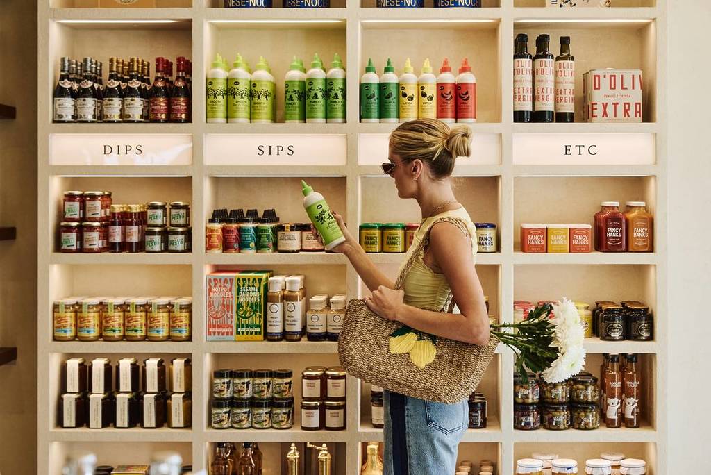 woman holding a bottle in the pantry staples section of Breadcetera