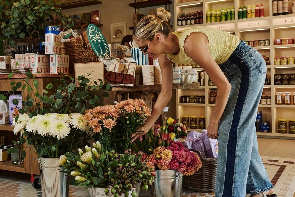 woman looking at flower bouquets at Breadcetera