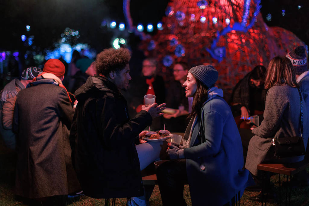 a couple having a chat over some sliders outdoors in winter for RISING festival