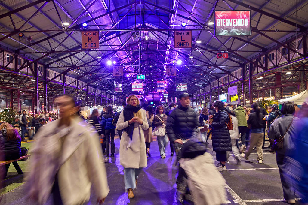 people walking under the sheds at Queen Victoria Market during a night market