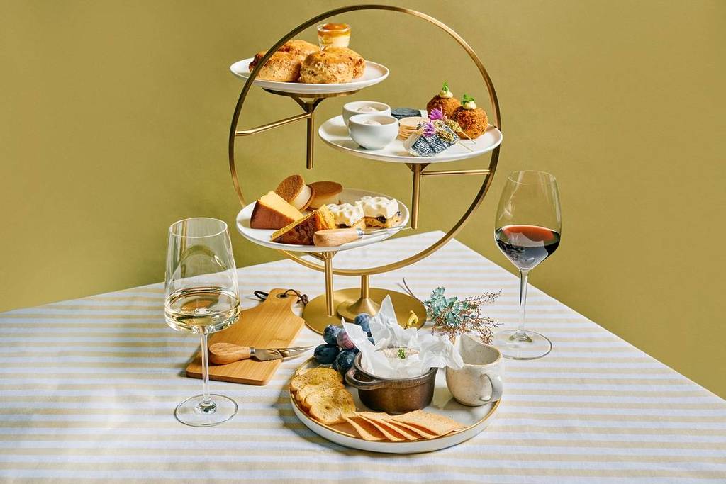 tiers of cheesy bites for High Cheese and two glasses of wine