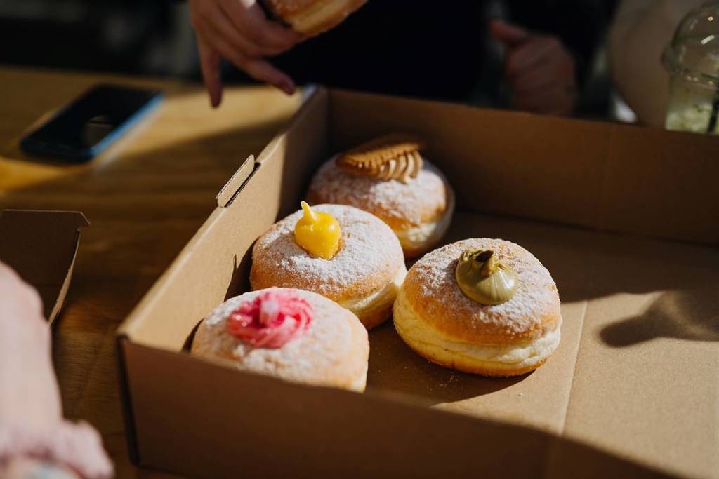 donuts with colourful fillings peeking out the top in a box for Melbourne Donut Festival