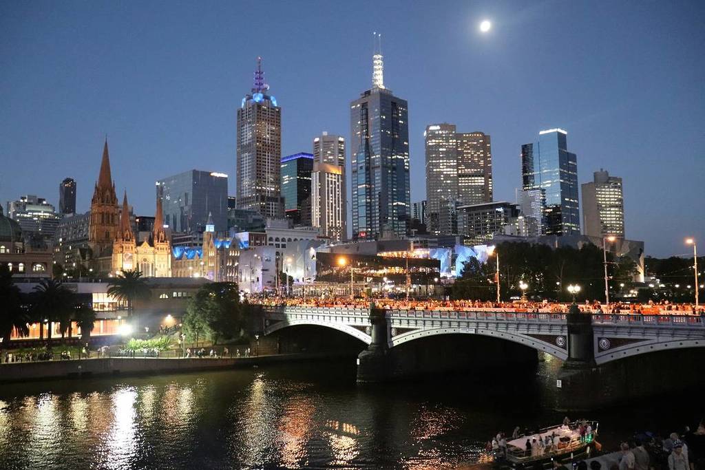 Melbourne skyline and Yarra River at night, with full moon in the sky