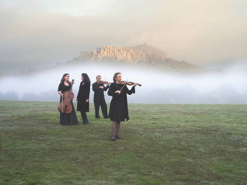 classical musicians performing in front of Hanging Rock on a foggy winter day for Woodend Winter Arts Festival