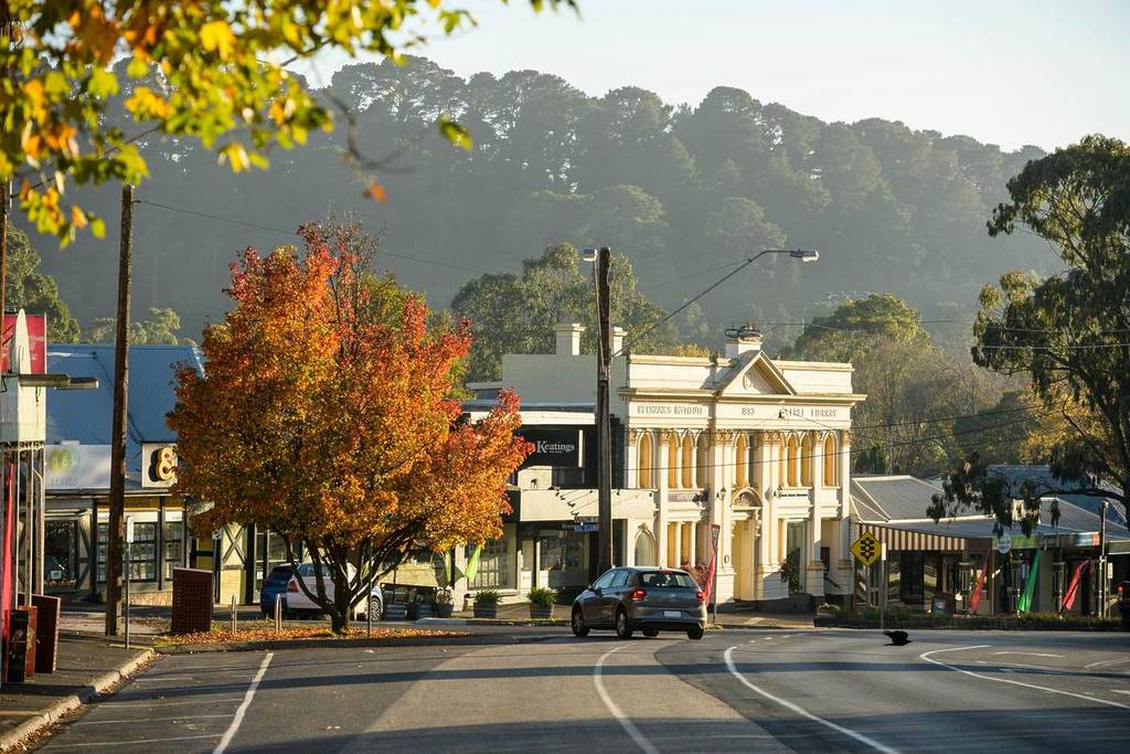 street of Woodend, with an old building and an autumn tree