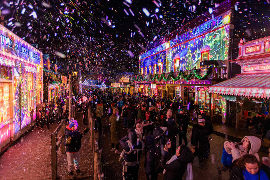 people watching light projections under falling snow at Winter Wonderlights as part of Ballarat Winter Festival