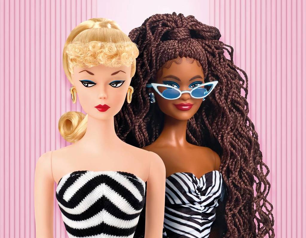 two Barbie dolls in black and white striped swimsuits
