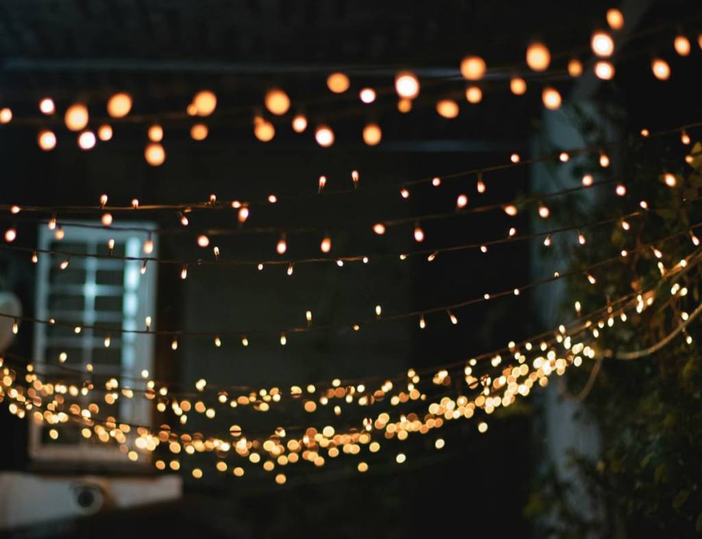 twinkling festoon lights above a street at night