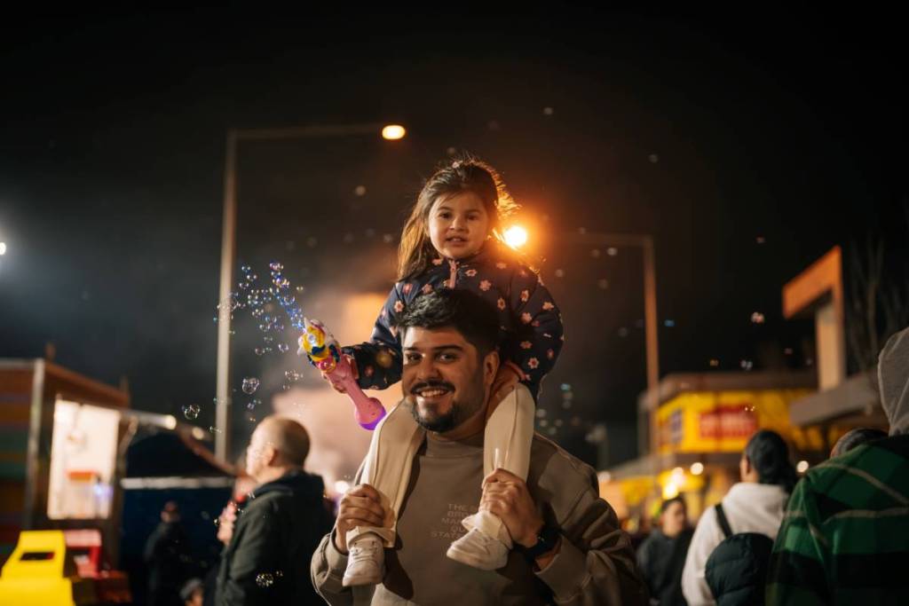 father carrying daughter on shoulders at Firefly Night Market