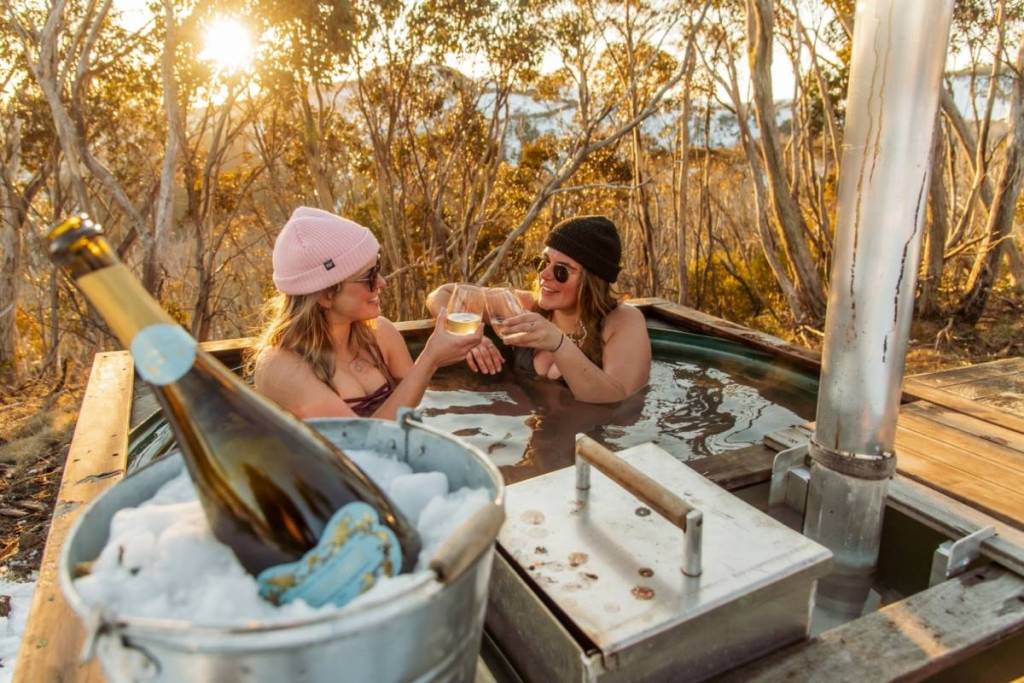 two women in the hot tub with wine on Mount Hotham on a sunny day