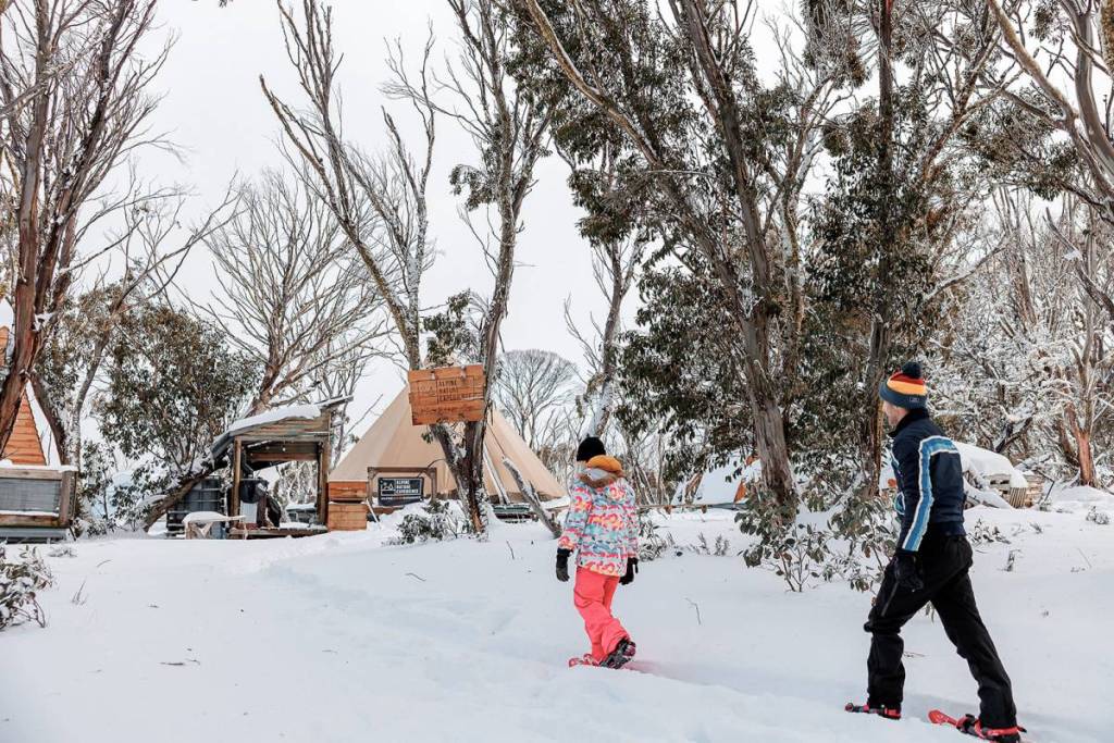 two people snowshoeing towards the eco-village