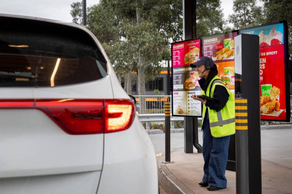 Wendy's staff member greeting a car in the drive-thru