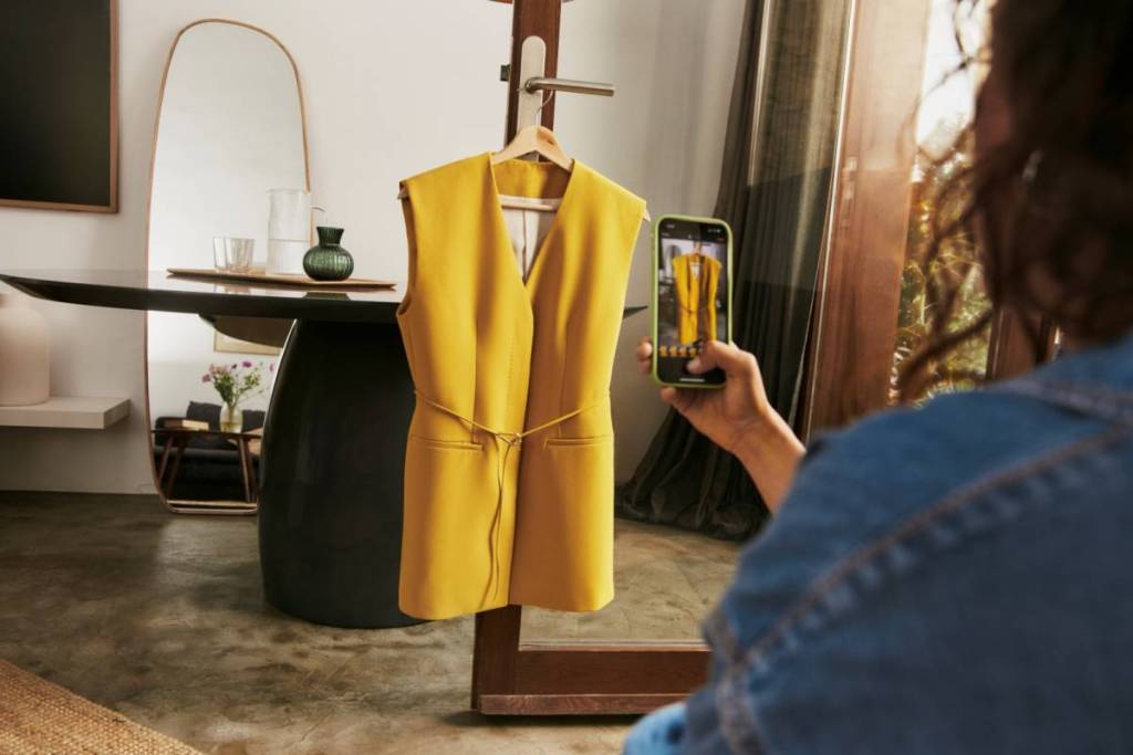 woman taking photo of yellow piece of clothing to sell on Vinted