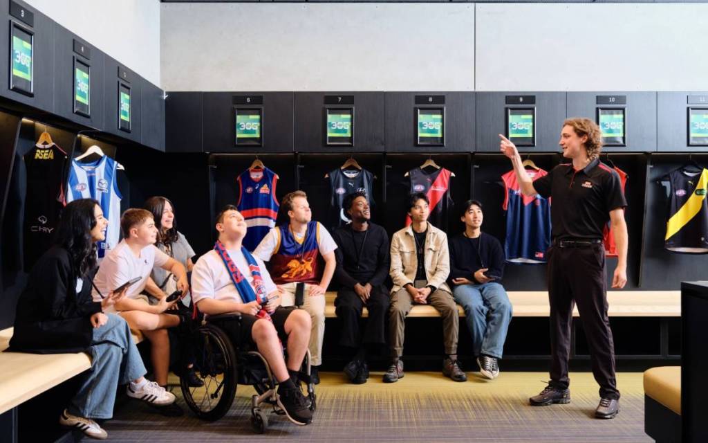 visitors inside a change room or locker room on a tour of Marvel Stadium