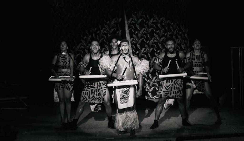 A group of men and woman performing traditional Fijian dance at the Fijian Flying Circus Tour.