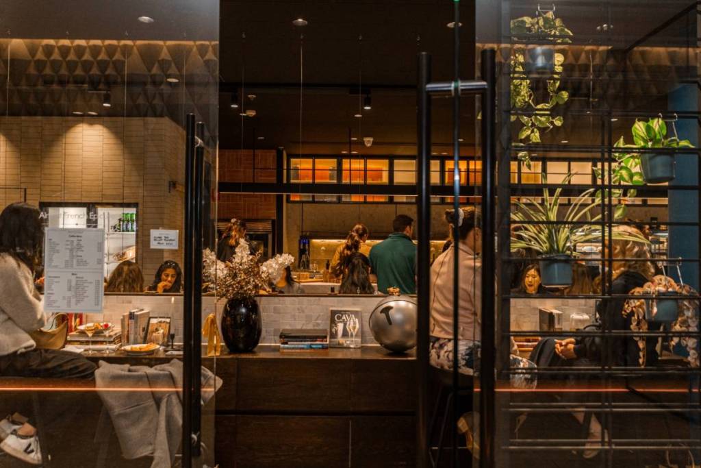 outside looking through the doors of Almost French Epicure at night