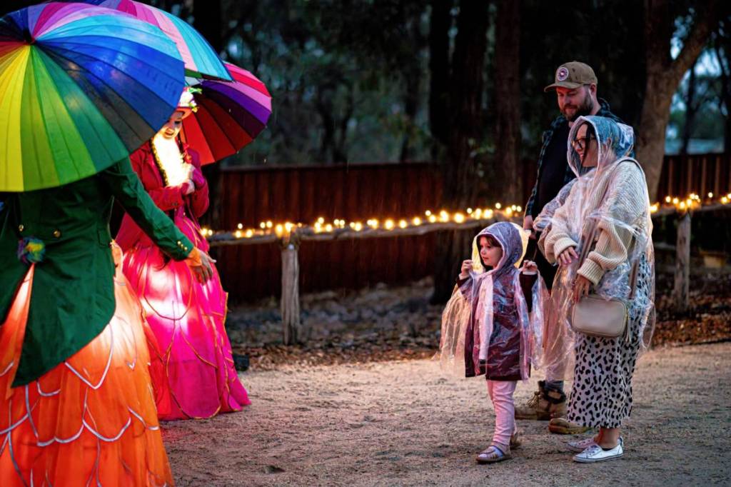 a family seeing roving performers at The Great Stupa of Universal Compassion on a rainy evening