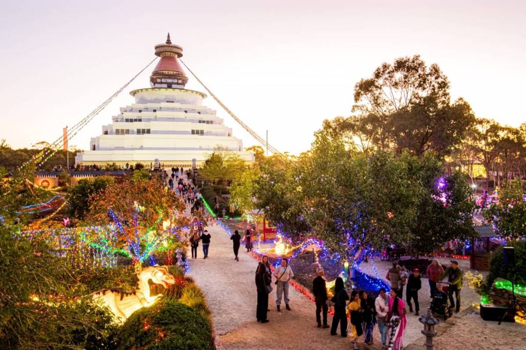 families exploring Peace Park lit by fairy lights at Great Stupa of Universal Compassion