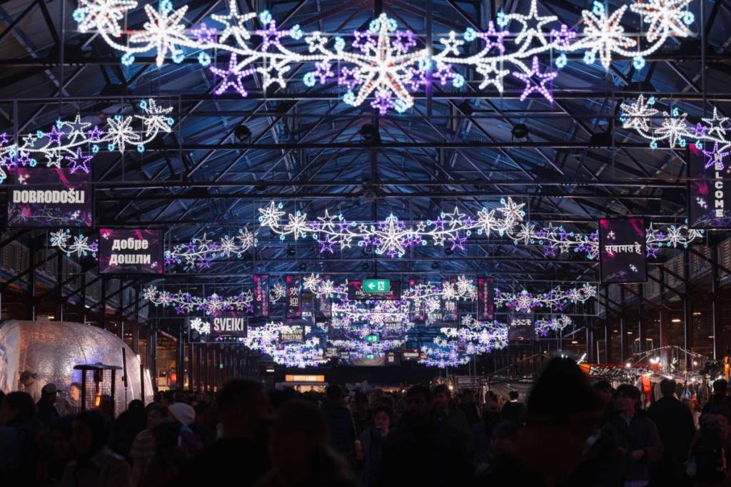 snowflake lights above visitors at the Winter Night Market during Christmas in July