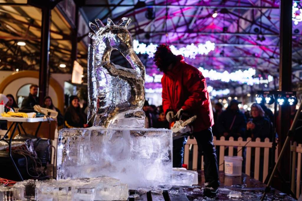 someone making an ice sculpture at Winter Night Market