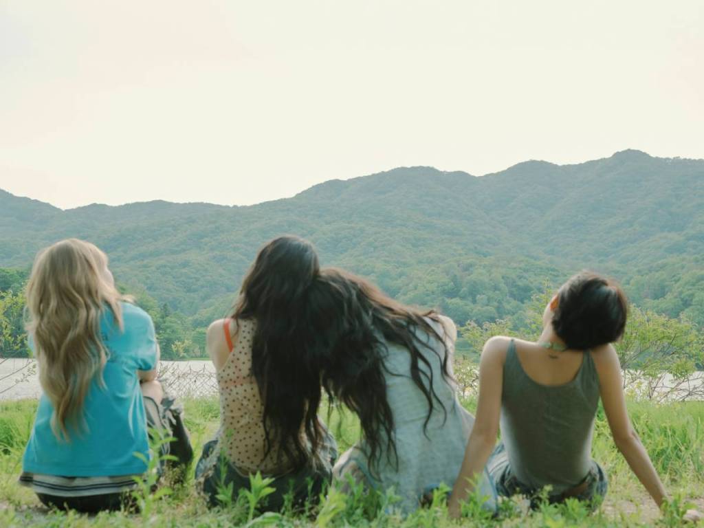 MAMAMOO members from the back as they look out at the park 
