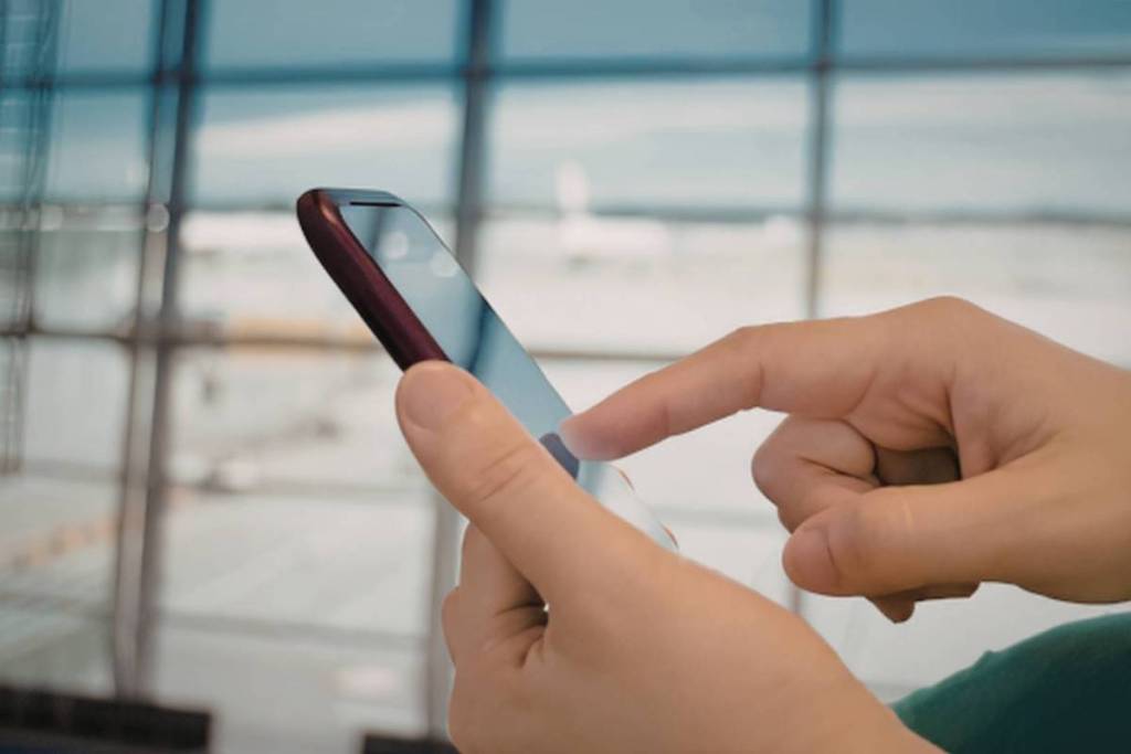 close up of hands using phone at an airport